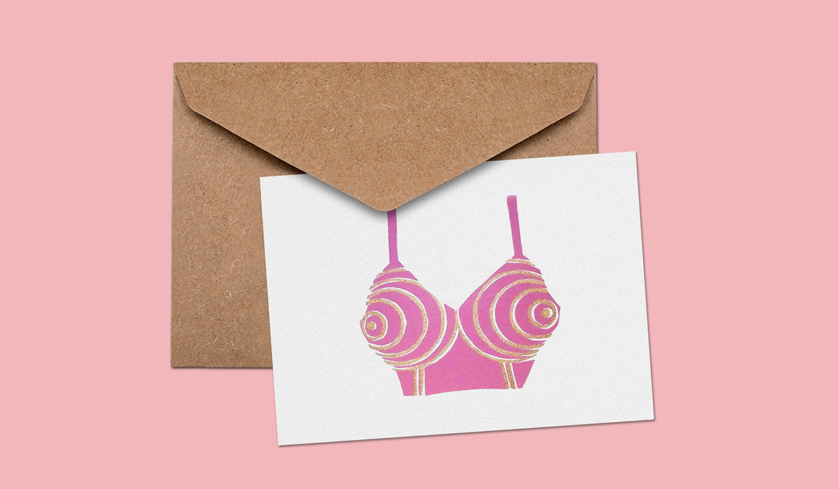 A screenprinted card of a pink bullet bra with sparkling gold stripes.